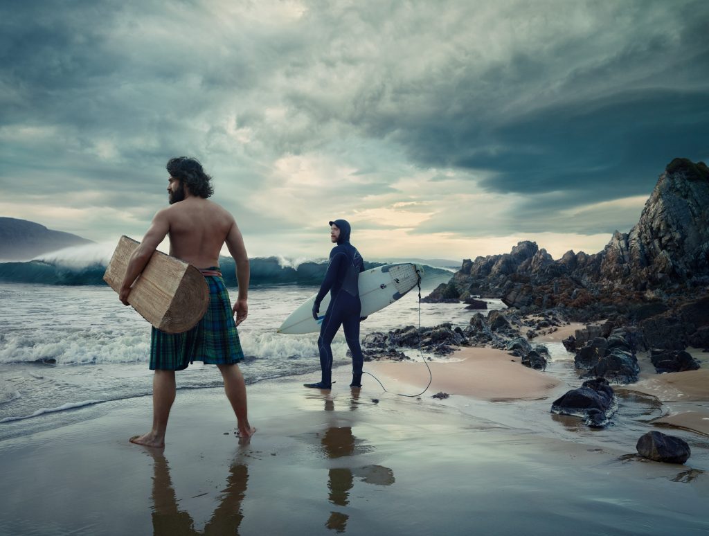 man wearing kilt and surfer on beach in Scotland photo by Todd Antony